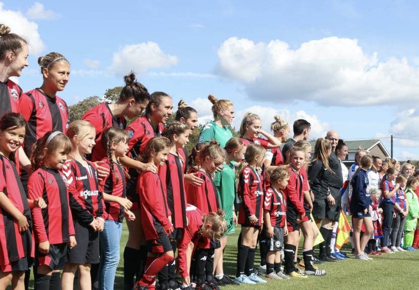 Women's team lines up for a fixture with mascots
