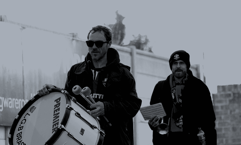 Image of supporters arriving at ground with large drum